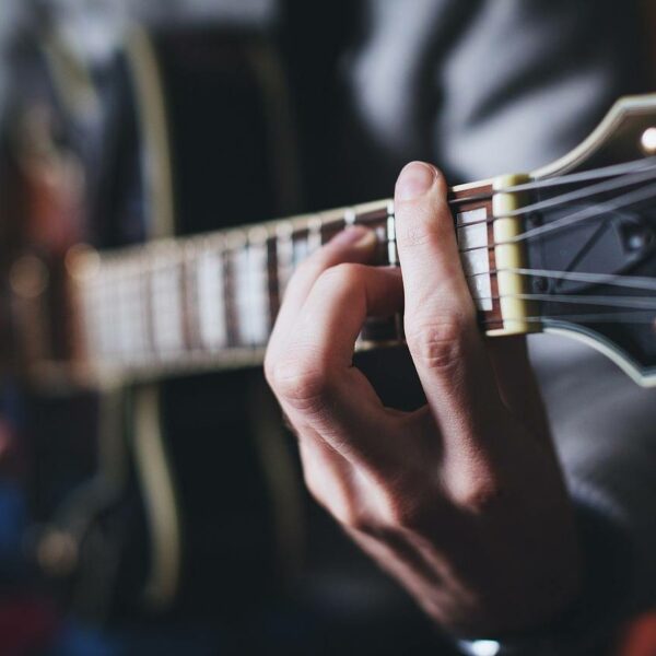 Participant learning guitar chords in a fun, social, group music class.