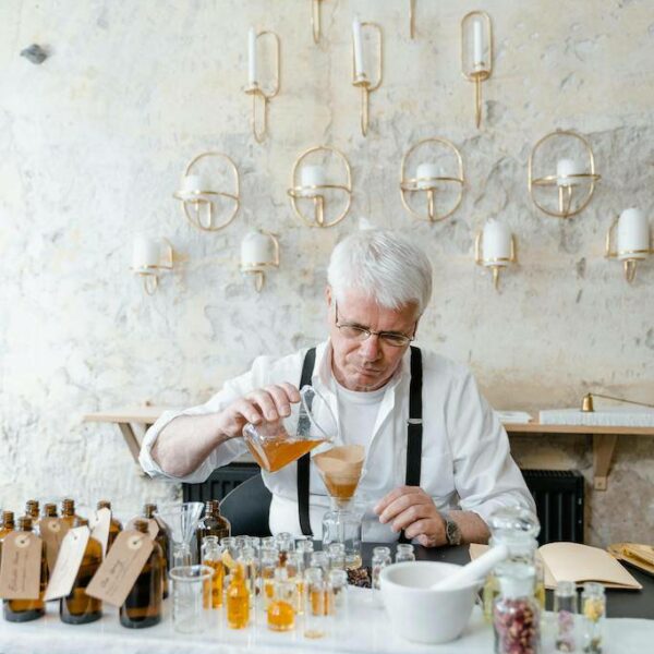 Participant blending essential oils to create a custom fragrance in a perfume workshop.