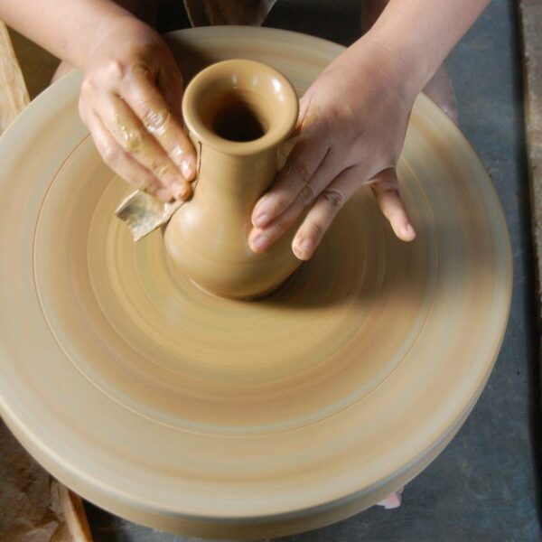 Hand-ons clay molding on a wheel by participants in a pottery workshop in Abu Dhabi.